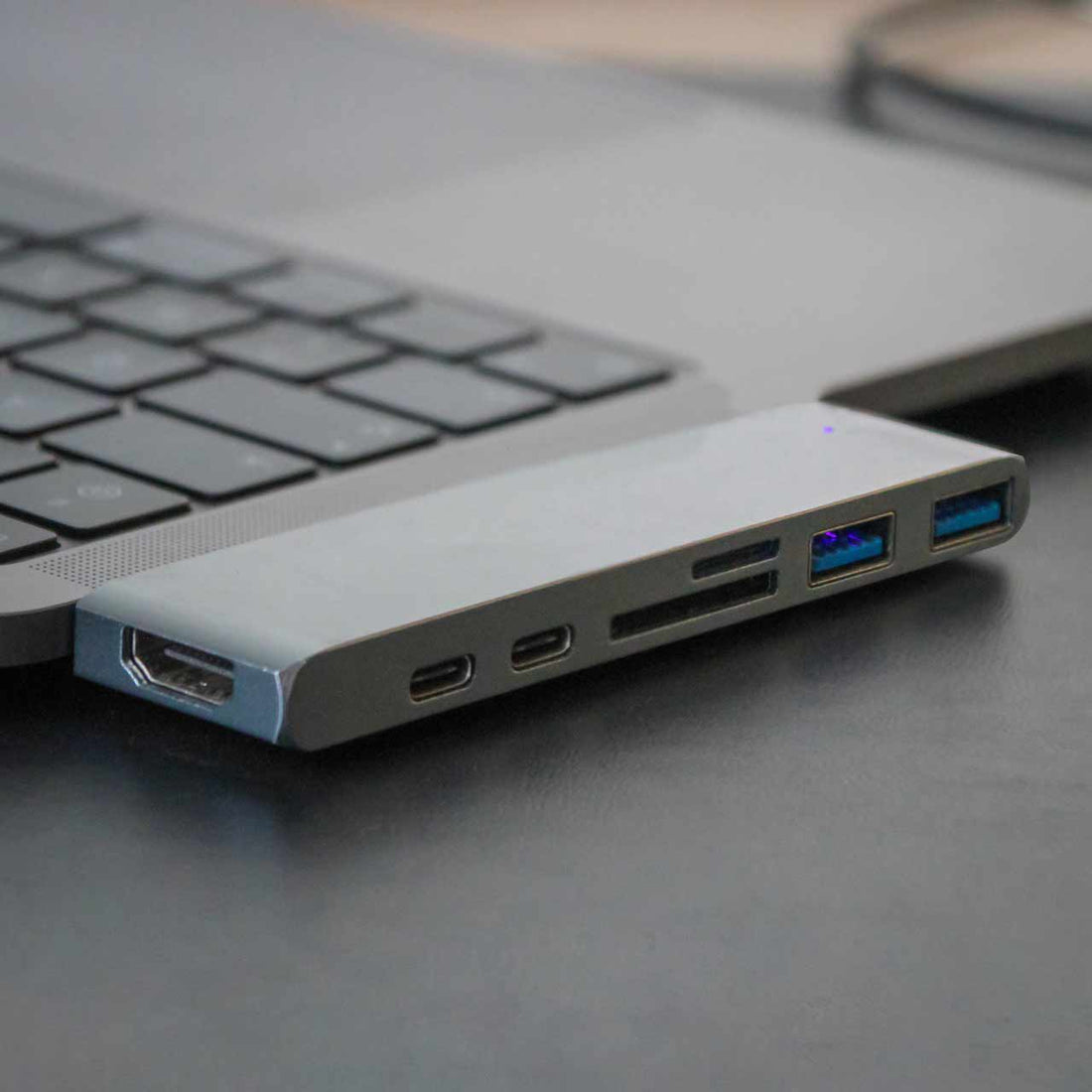 Texte alternatif (alt text) en français :  
**Adaptateur USB-C 7-en-1 connecté à un ordinateur portable moderne**