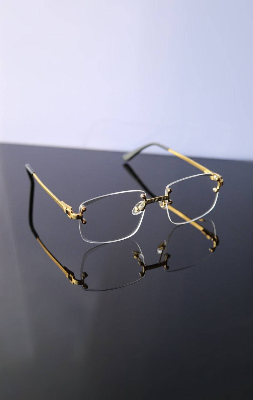 Lunettes de soleil Shine à verres transparents et monture dorée. Élégance discrète et style raffiné avec protection UV légère.