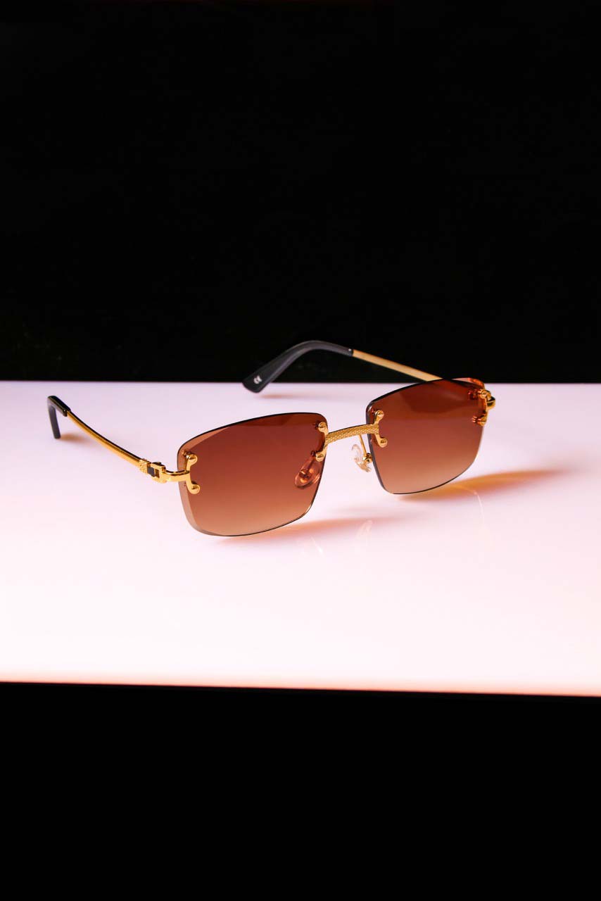 Lunettes de soleil Shine avec verres marron et monture dorée. Look raffiné et protection UV idéale pour les journées ensoleillées.